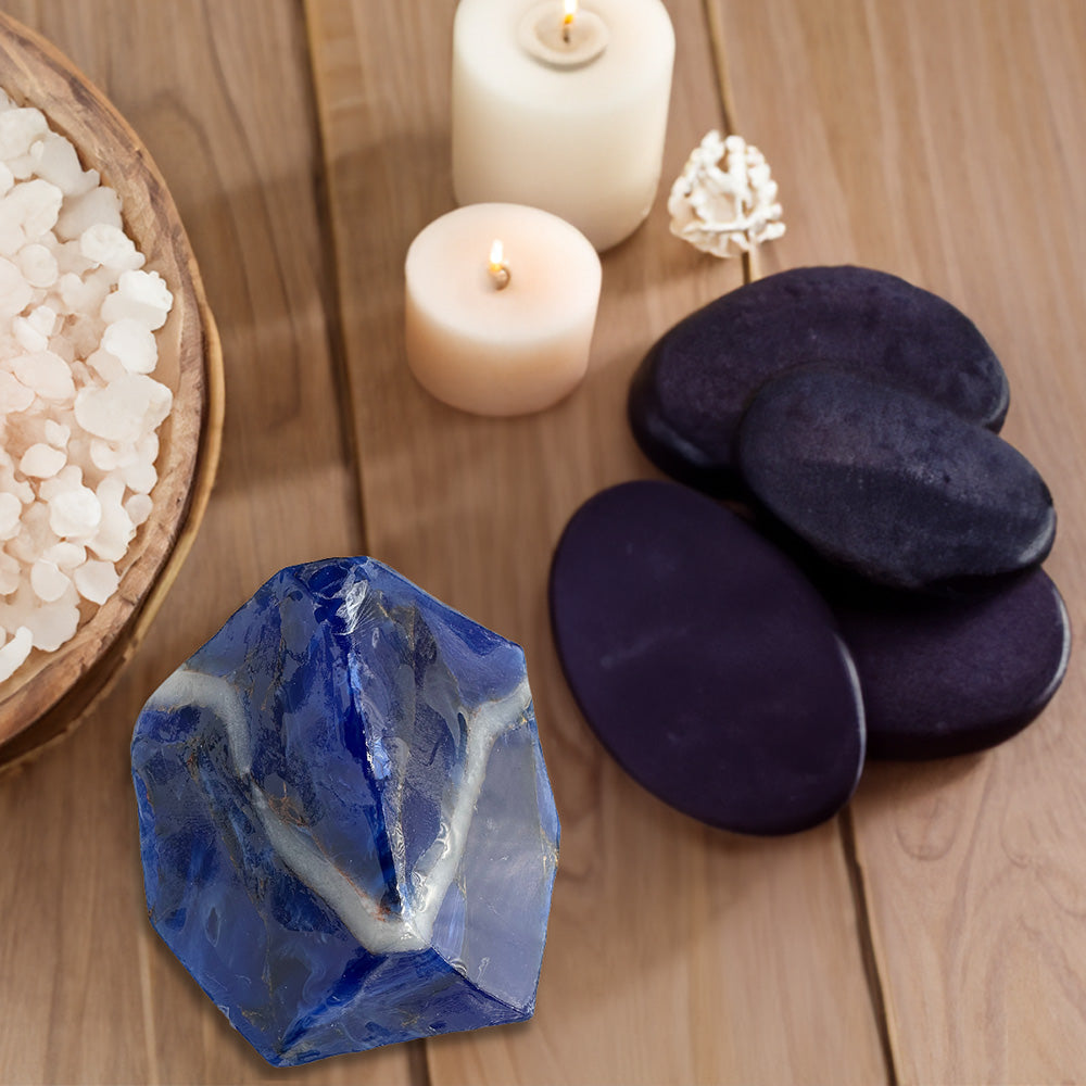 rengöra blue crystal soap positioned on a table alongside a candle and black stones