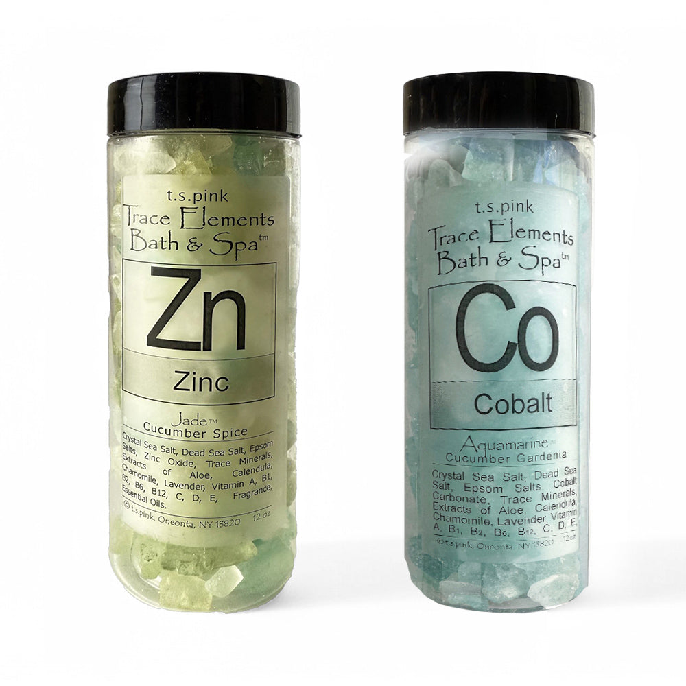 Image of two premium bath salt jars, one with striking blue "Cobalt Bath Salts" and the other with soothing green "Zinc Bath Salts." The transparent containers with black lids highlight the rich textures of the mineral-infused salts.