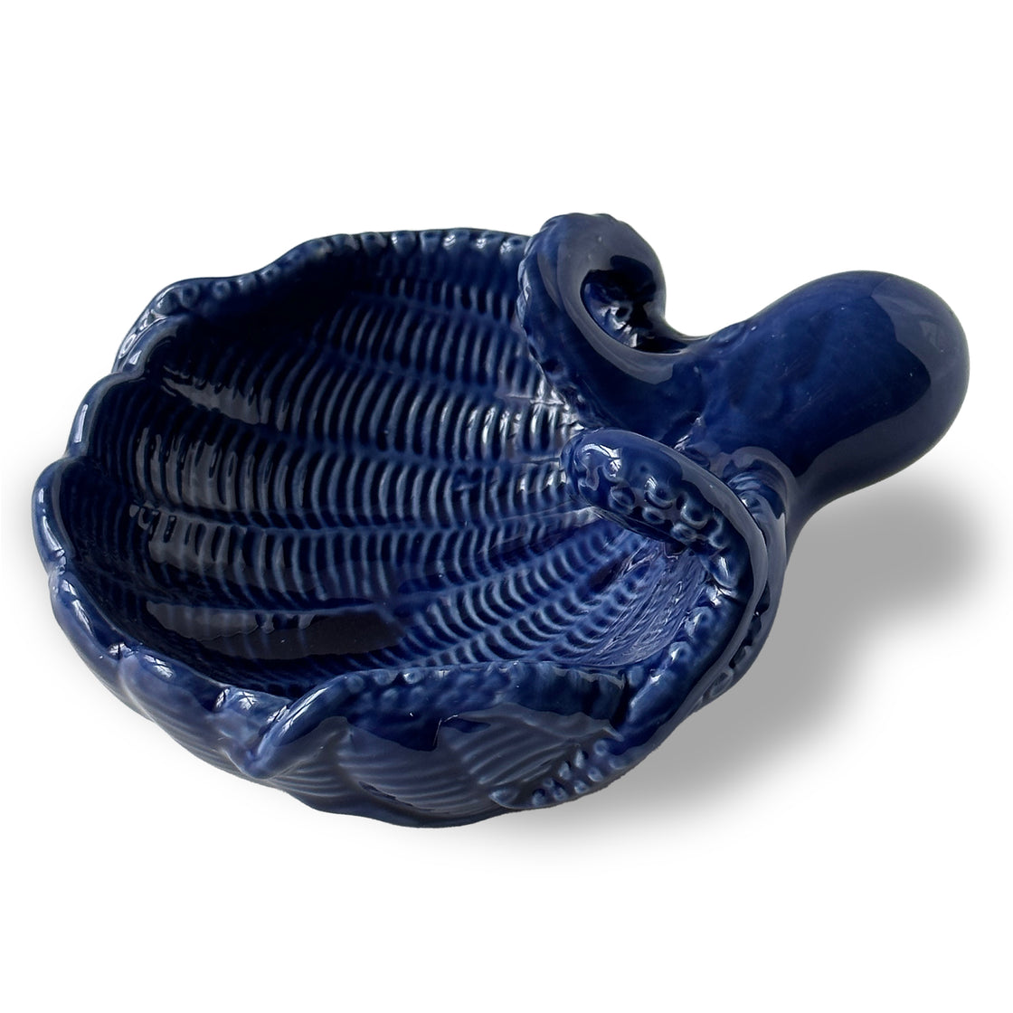 Angled close-up of glossy blue octopus trinket tray showing textured ceramic finish and curved tentacle rim