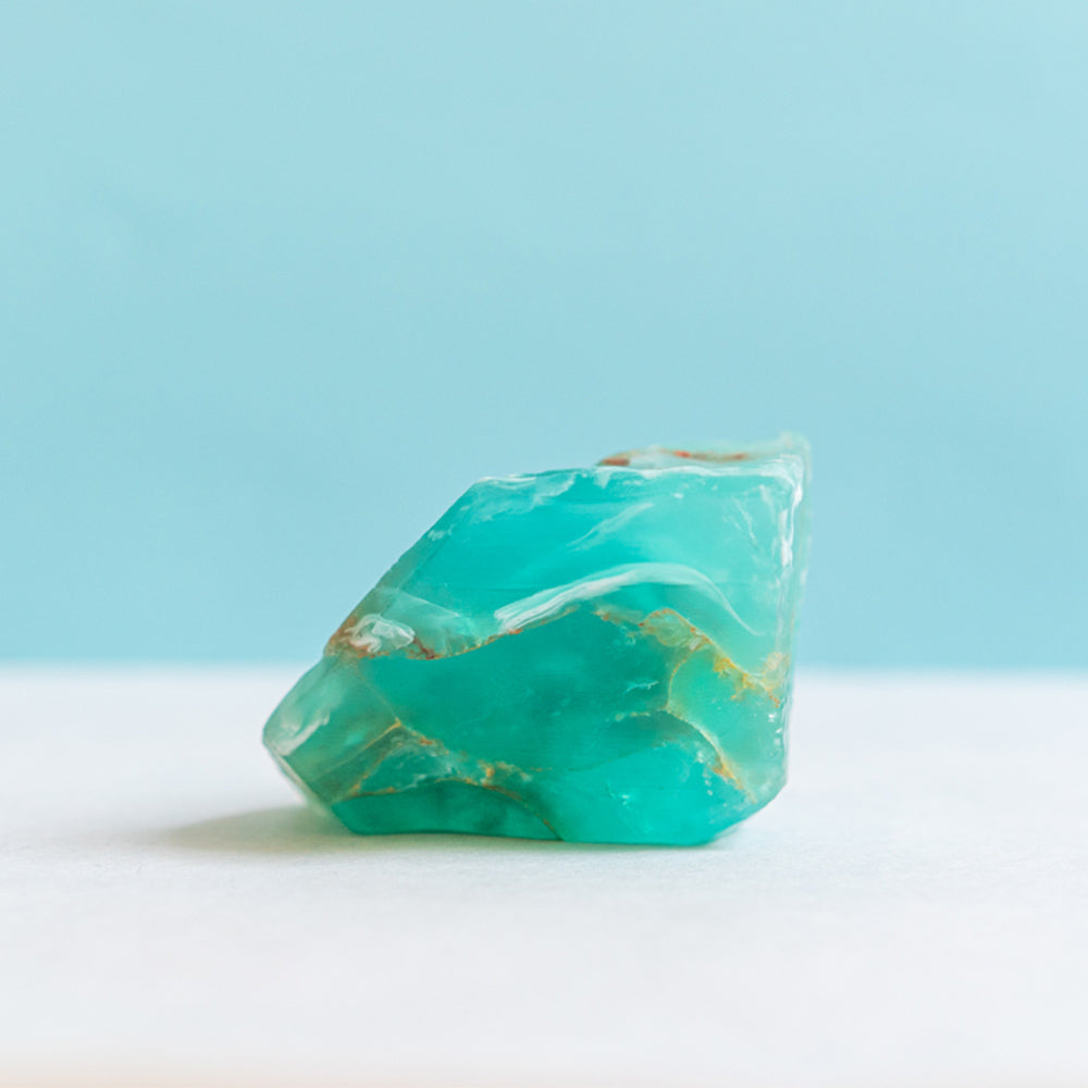 The turquoise blue teal soap resembles an authentic rock, set against a softly blurred turquoise background