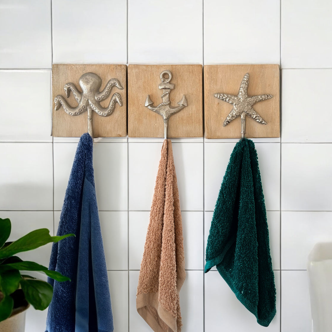 Nautical towel hook set on white tiles, each holding a towel—perfectly styled in a beach-themed bathroom.