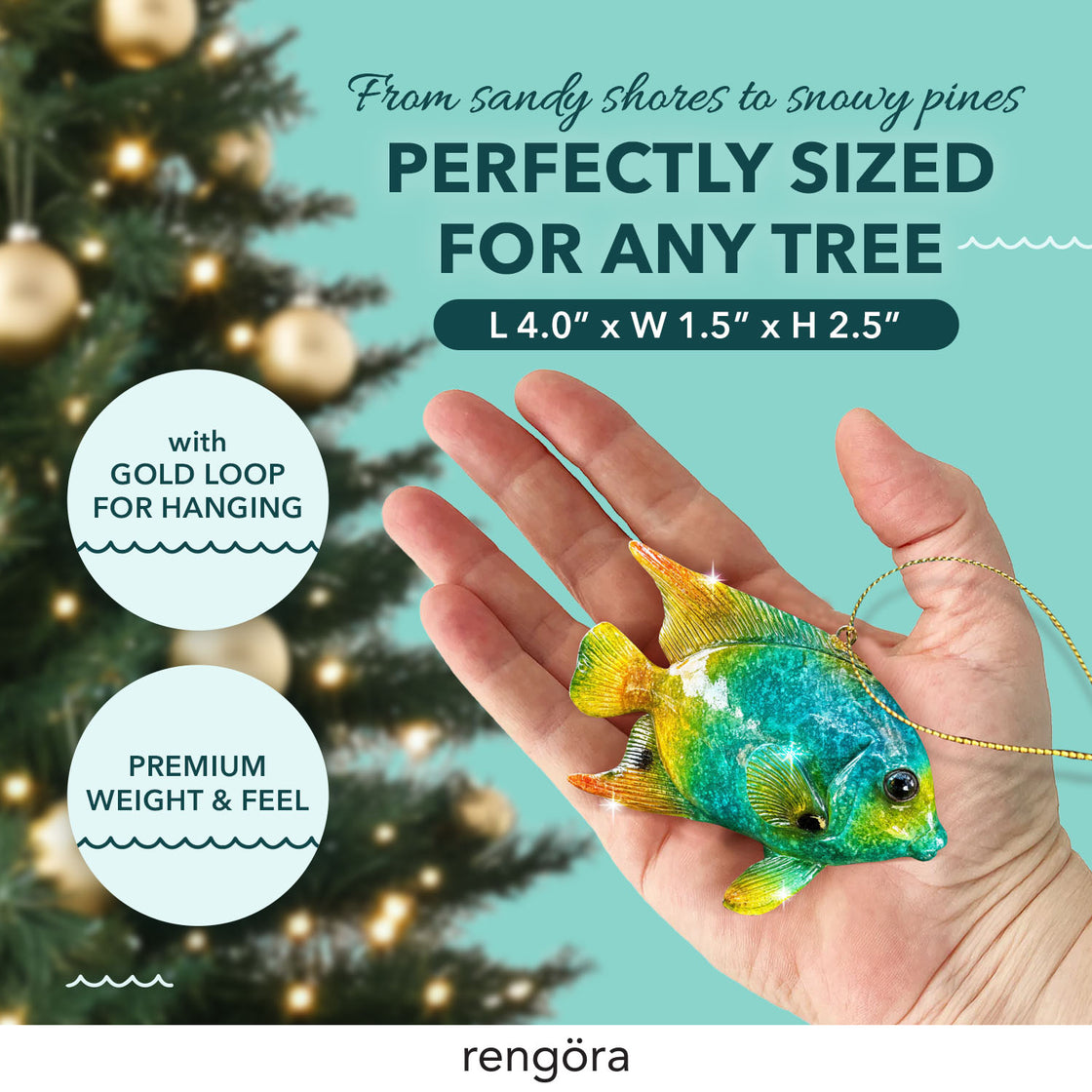 A person’s hand displays the tropical fish ornament, highlighting its vibrant colors and realistic texture. The ornament is set against a blurred background of a decorated Christmas tree with golden lights.