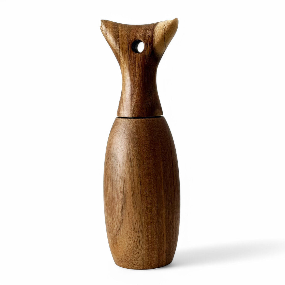 Minimalist hand-turned wooden grinder shown against a white background, highlighting its unique, curved silhouette and fine craftsmanship.