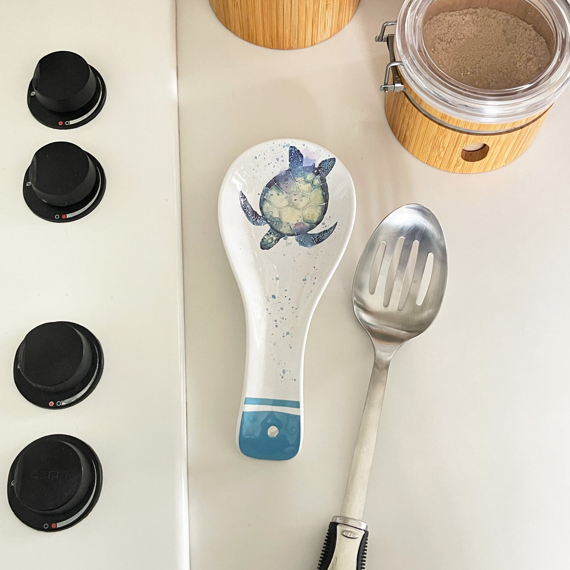sea turtle spoon rest shown in kitchen with large stainless steel slotted spoon