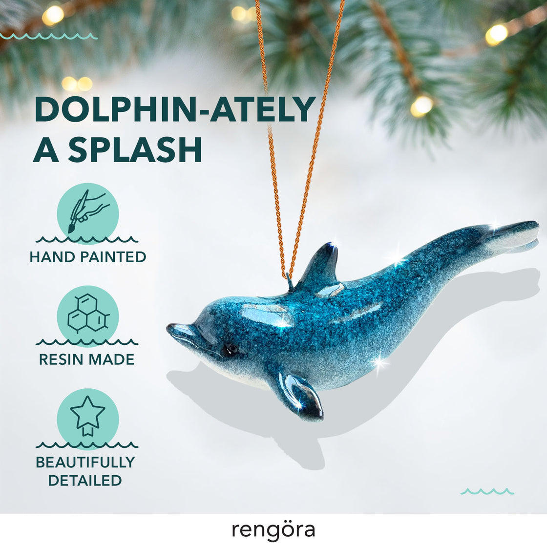 A glittering blue dolphin ornament is shown against a white background with pine branches. 