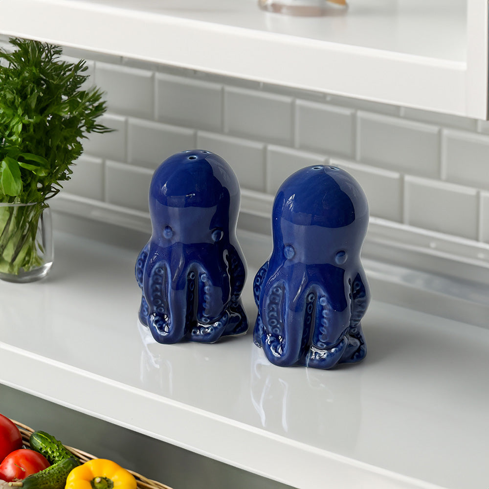 Royal blue (almost navy) set of cute ceramic octopus salt and pepper shakers sitting on a kitchen counter
