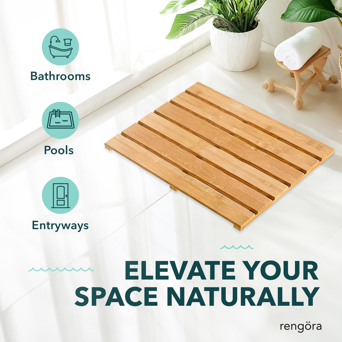 A bamboo bath mat placed on a shiny white floor in a bright space with plants and a rolled towel nearby. The natural wood tones create a warm, elegant look for bathrooms, entryways, or poolside areas.