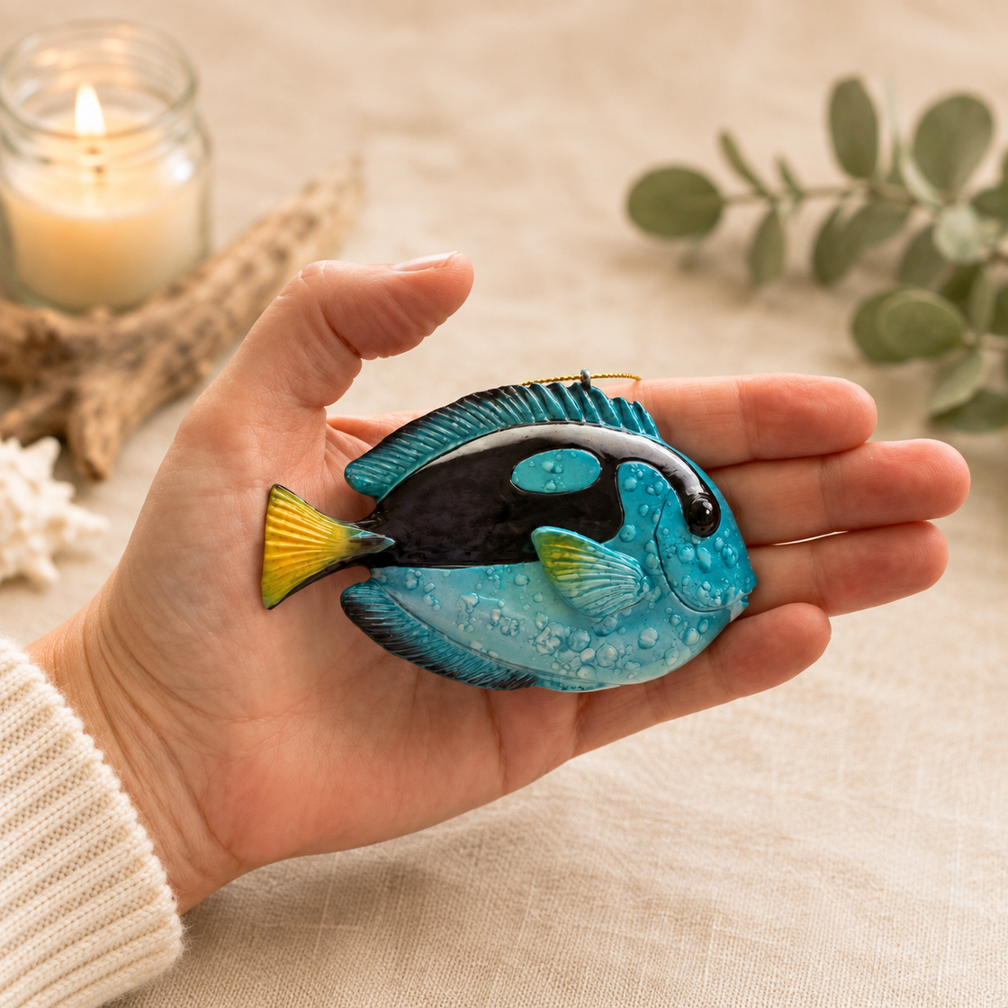Rengöra blue tang fish ornament resting in an open hand to show its size, shape, and hand-painted details.