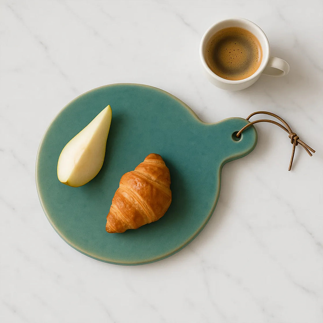 Rengöra teal ceramic serving board with croissant and espresso on marble countertop