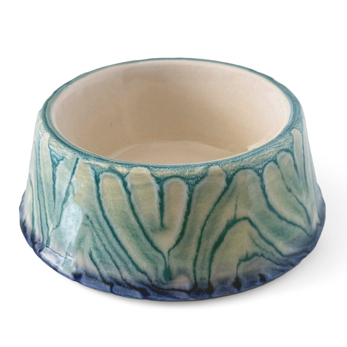 A standalone image of a rengöra blue and teal ceramic dog bowl with intricate marbled glaze patterns, photographed against a plain white background to highlight its unique design.