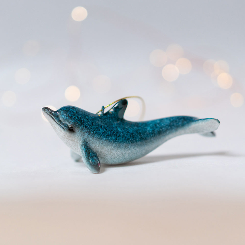 Hand-painted rengora blue dolphin ornament with a backdrop of softly blurred surroundings