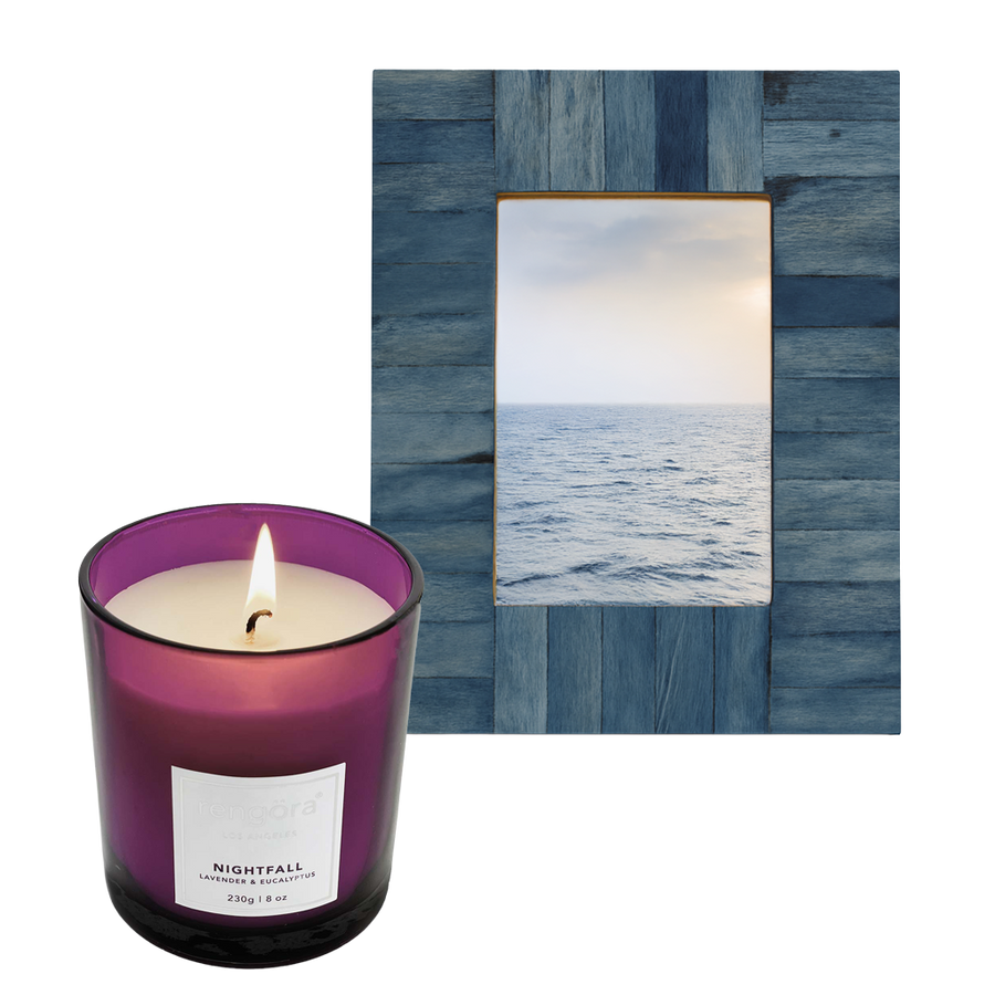 Lavender candle labeled 'Nightfall' in a purple glass jar next to a blue 'nautical-looking' picture frame.