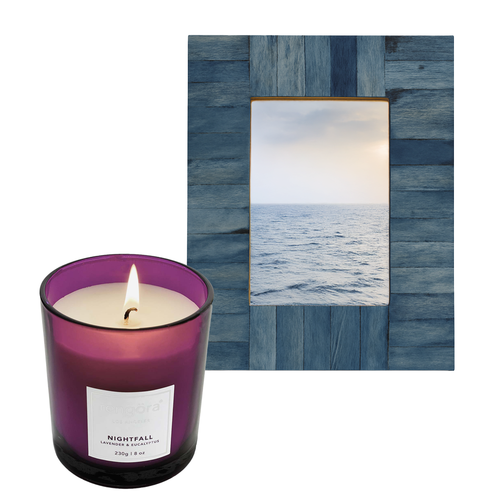 Lavender candle labeled 'Nightfall' in a purple glass jar next to a blue 'nautical-looking' picture frame.