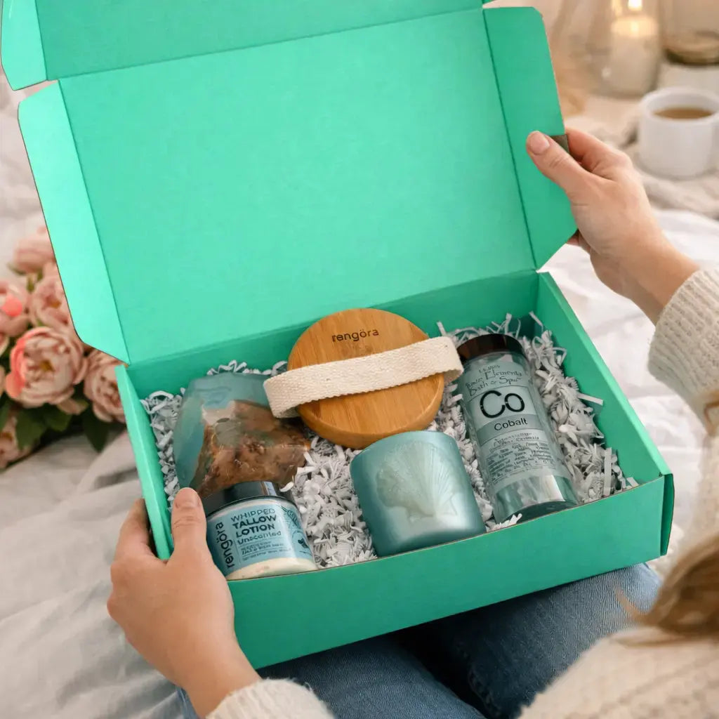 Teal gift box with skincare products on a soft surface