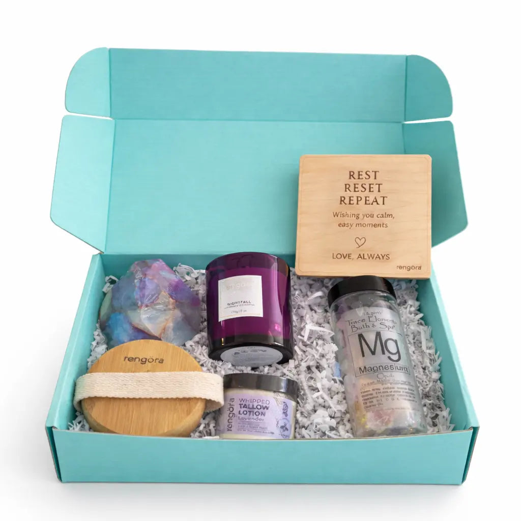 Gift set with candles, lotion, and a soap in a teal box on a white background