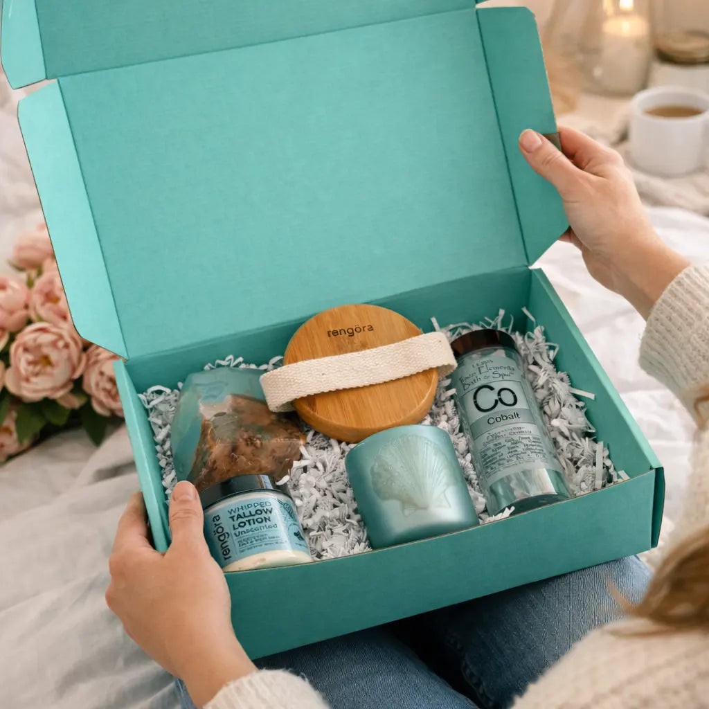 Teal gift box with skincare products on a soft surface