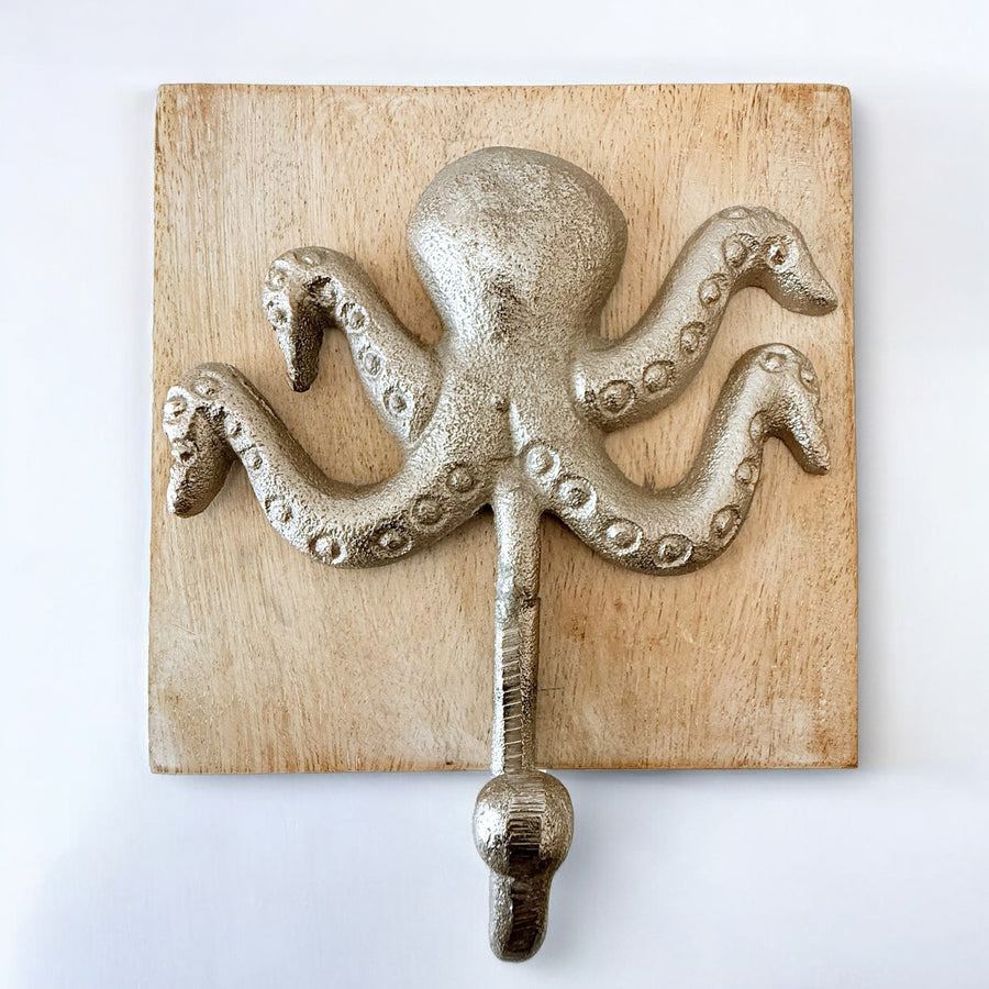 Close-up of a silver metal octopus wall hook mounted on a natural wood square base, photographed against a white background.