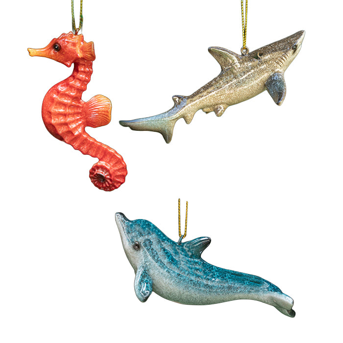 Three decorative ornaments shaped like a seahorse, shark, and dolphin on a white background.