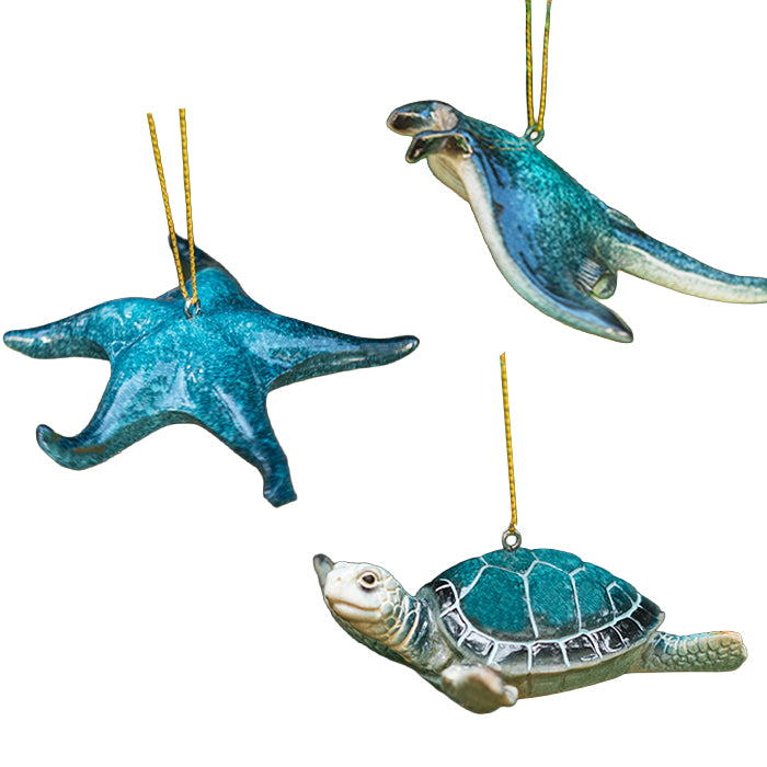 Set of three decorative ocean ornaments shaped like a blue starfish, a blue manta ray, and a blue sea turtle on a white background