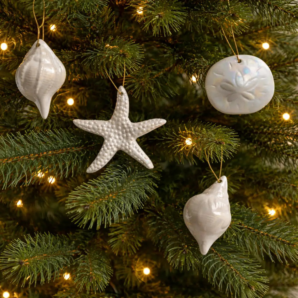 Decorative white starfish and shell ornaments on a Christmas tree with lights.
