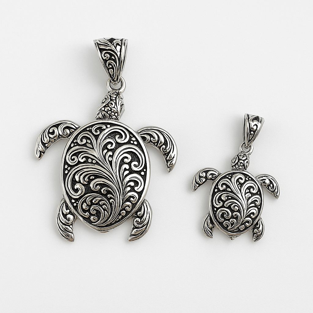 Two sterling silver turtle pendants in different sizes with intricate filigree detailing, displayed on a plain white background.