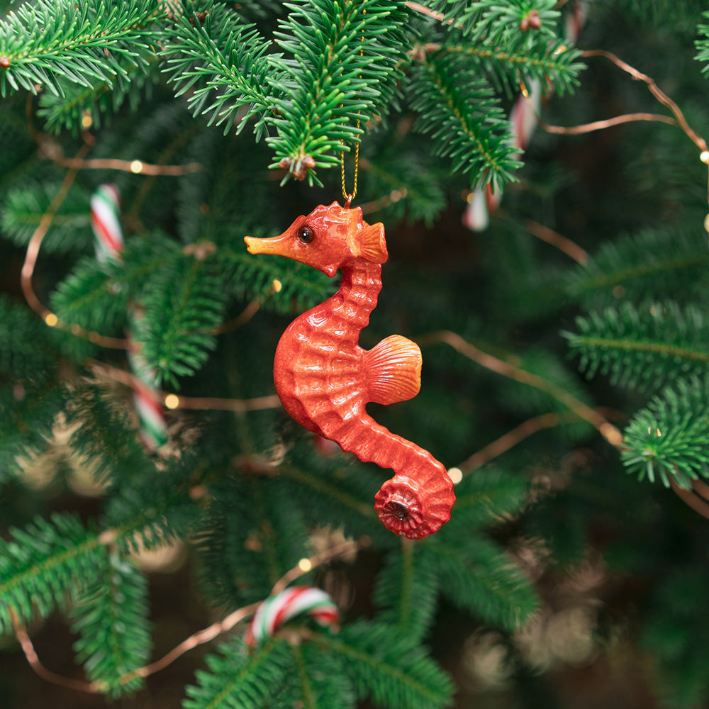 rengöra red seahorse ornament hangs gracefully from a Christmas tree branch