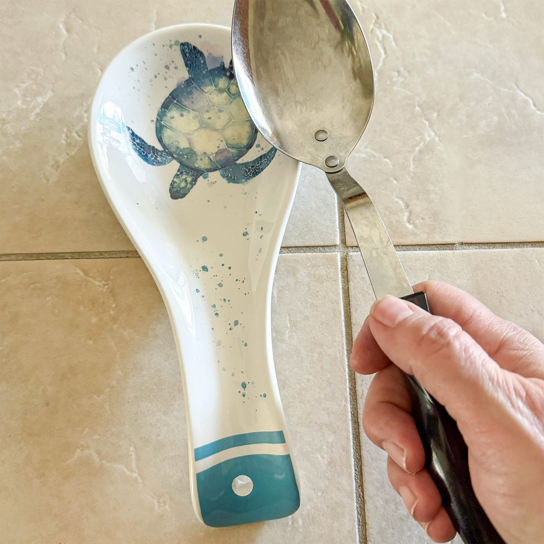 Sea turtle ceramic spoon rest holding cooking spoon on kitchen counter