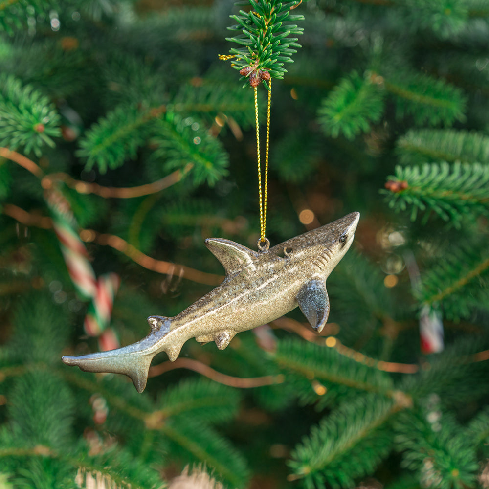 A shark-themed ornament hanging on a Christmas tree from rengöra