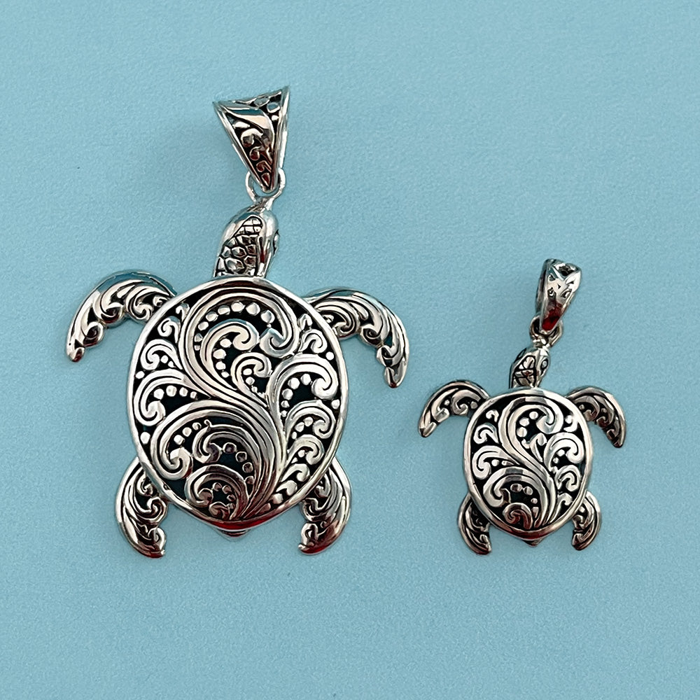 A large and small sterling silver (925) sea turtle pendant shown on a light blue background.