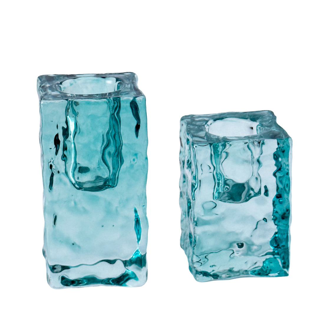 Two turquoise glass candle holders on a white background