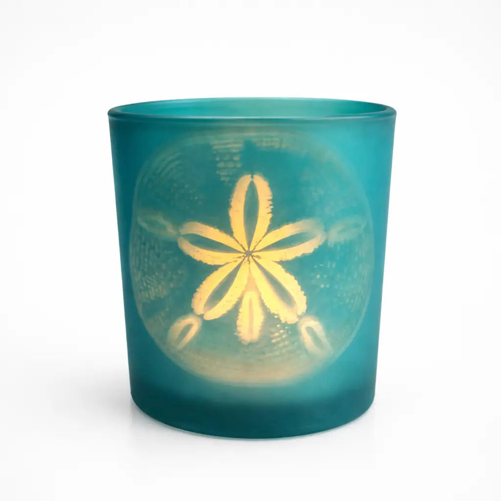 Teal glass candle holder with a sand dollar design on a white background