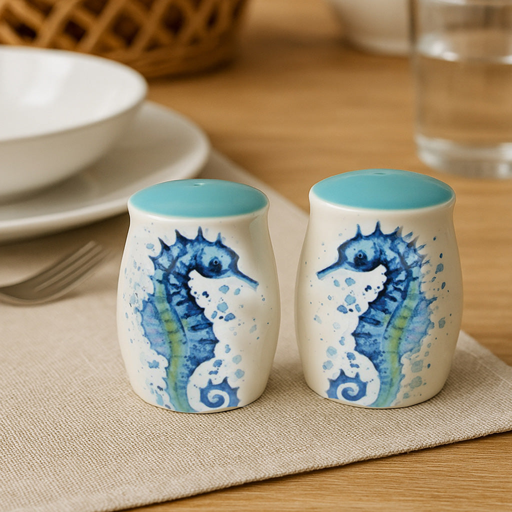 Ceramic seahorse salt and pepper shakers with watercolor-style blue design on a neutral dining table setting
