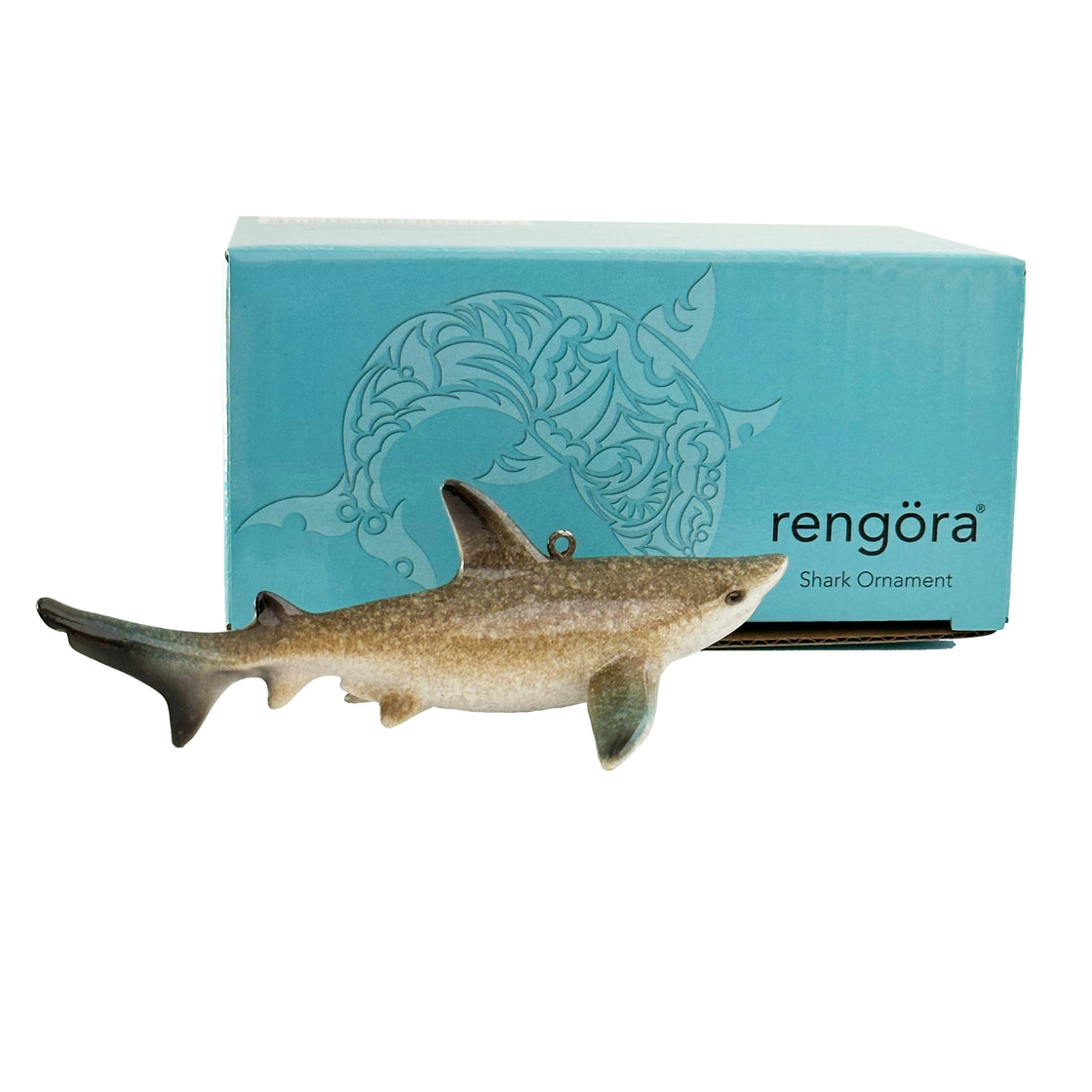 A side view of the rengöra shark ornament is displayed, revealing its packaging in the background against a plain white backdrop