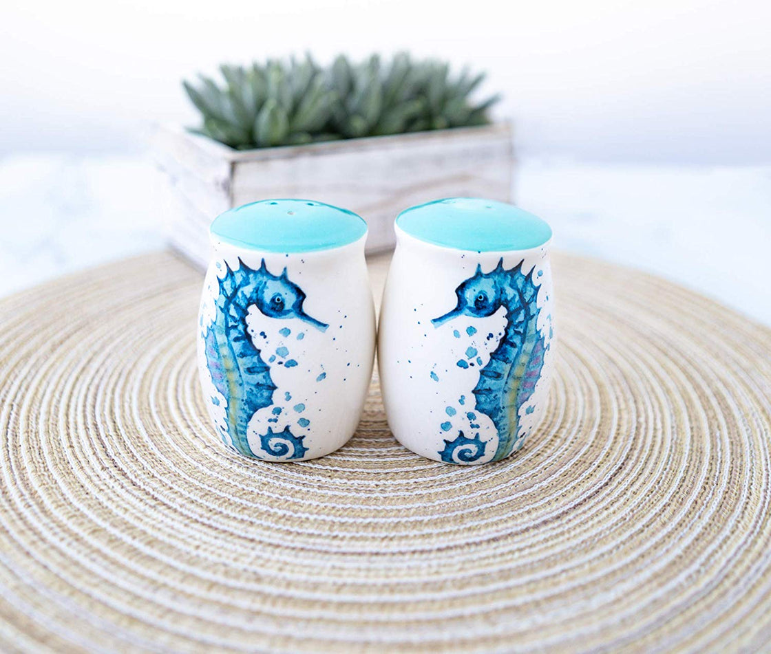 outdoor photo of seahorse salt and pepper shakers on a tan circular placemat with succulent plant in the background