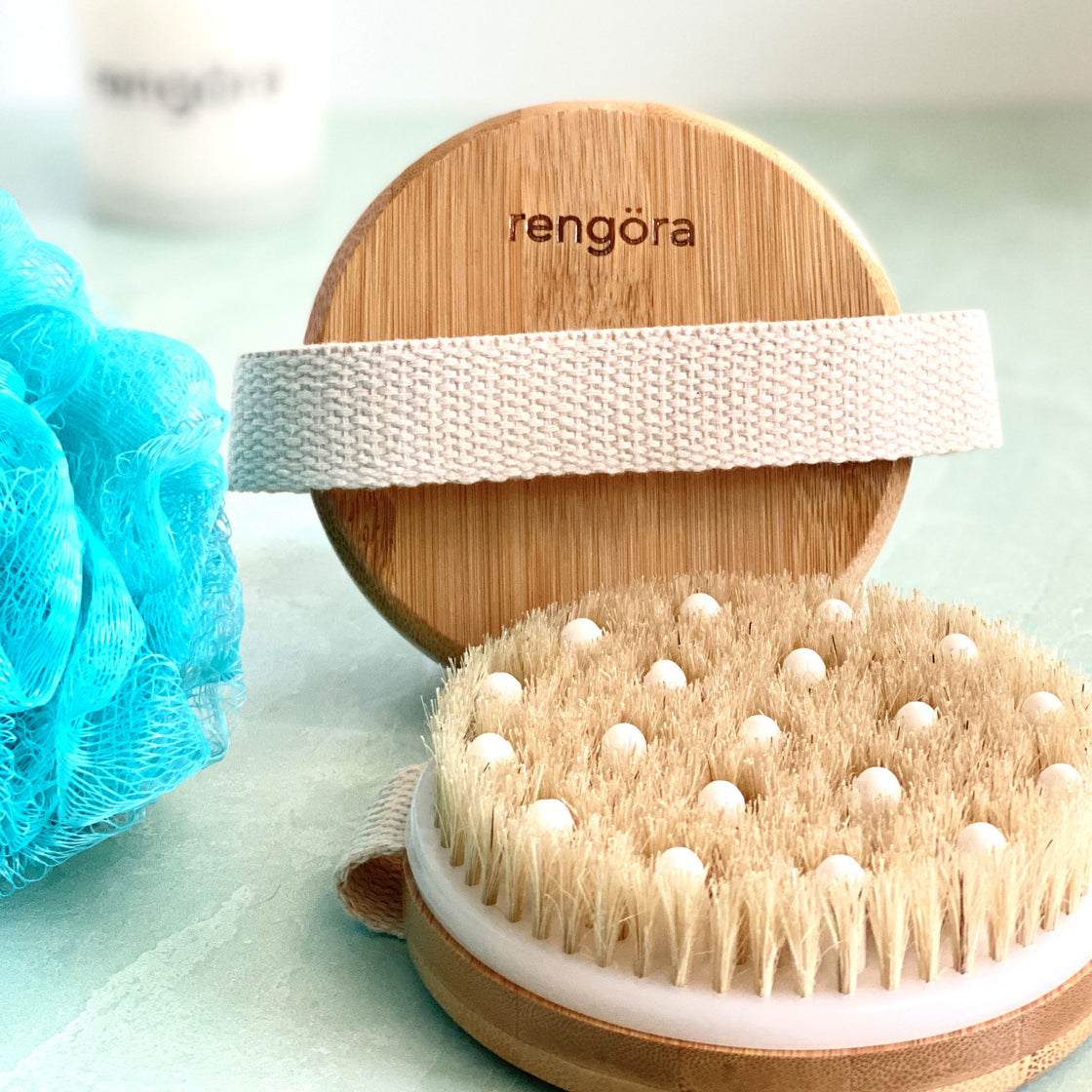 rengora massage nodules on bamboo circular brush shown with blue bath loofah
